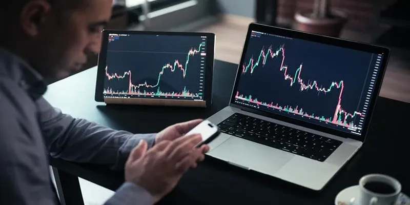 Analyzing financial data on a laptop to monitor stock investments